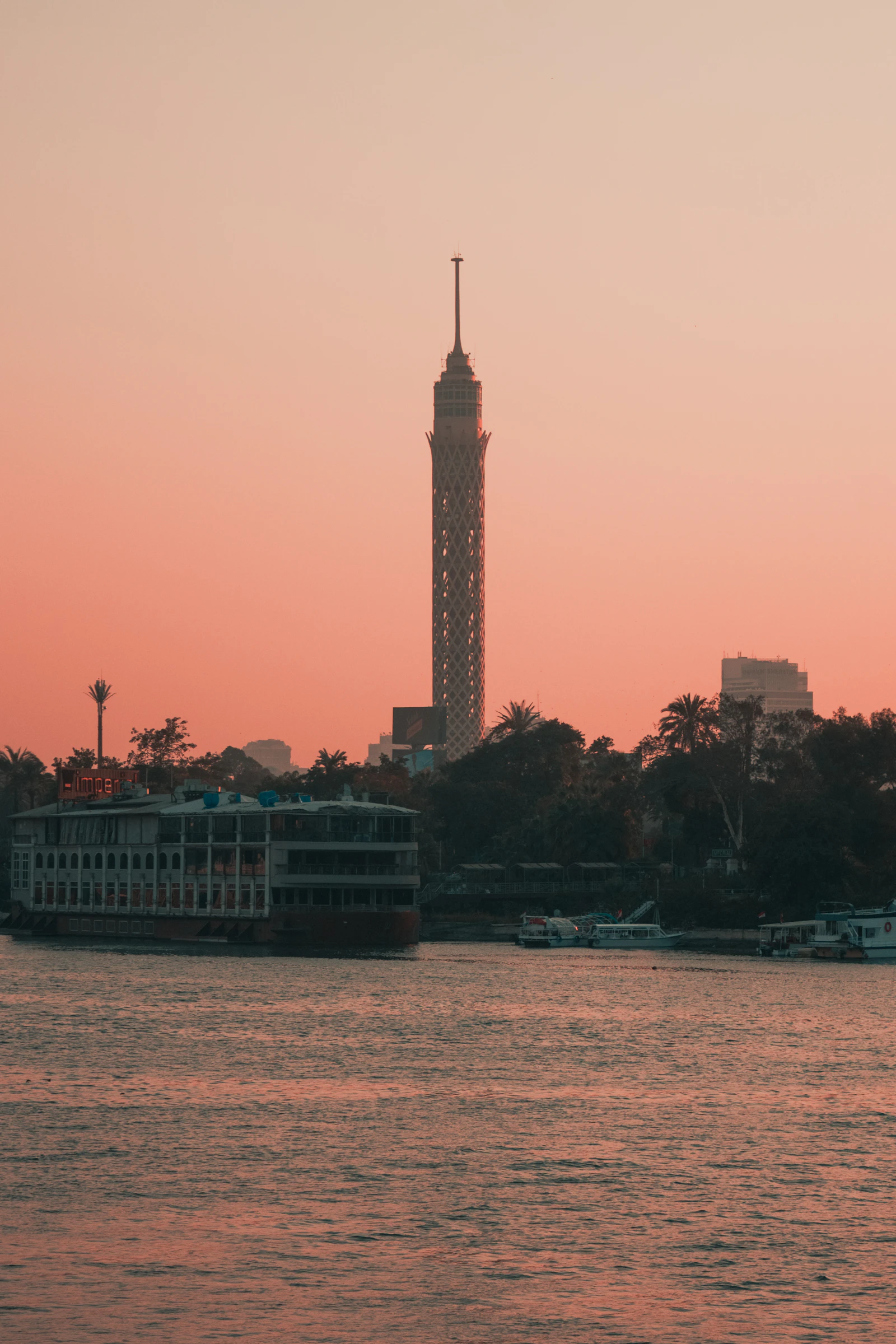 Cairo Tower at dusk with a Nile cruise boat